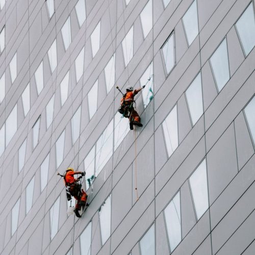 High-rise facade window cleaning on a modern skyscraper for urban maintenance.